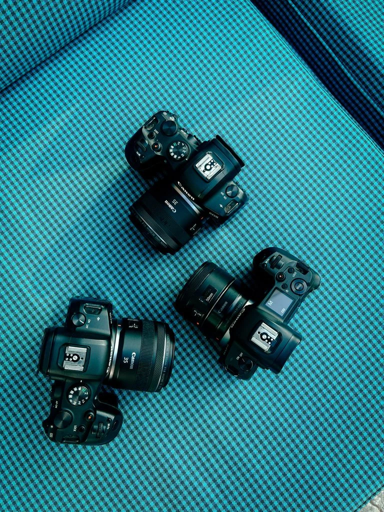 Three lenses — a fast 50, a 24-70 zoom, and a manual Leica Summicron — on the bench at Simon's.